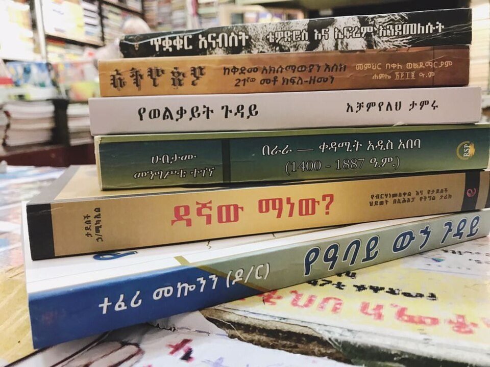 Une pile de livres aux titres écrits en amharique